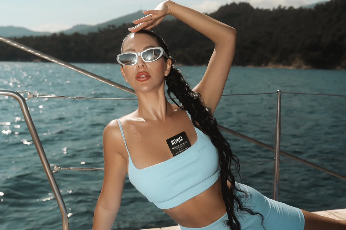 A participant of the Pilates on a Yacht retreat on the deck of a catamaran in the Aegean Sea, with a Smart Strips sachet