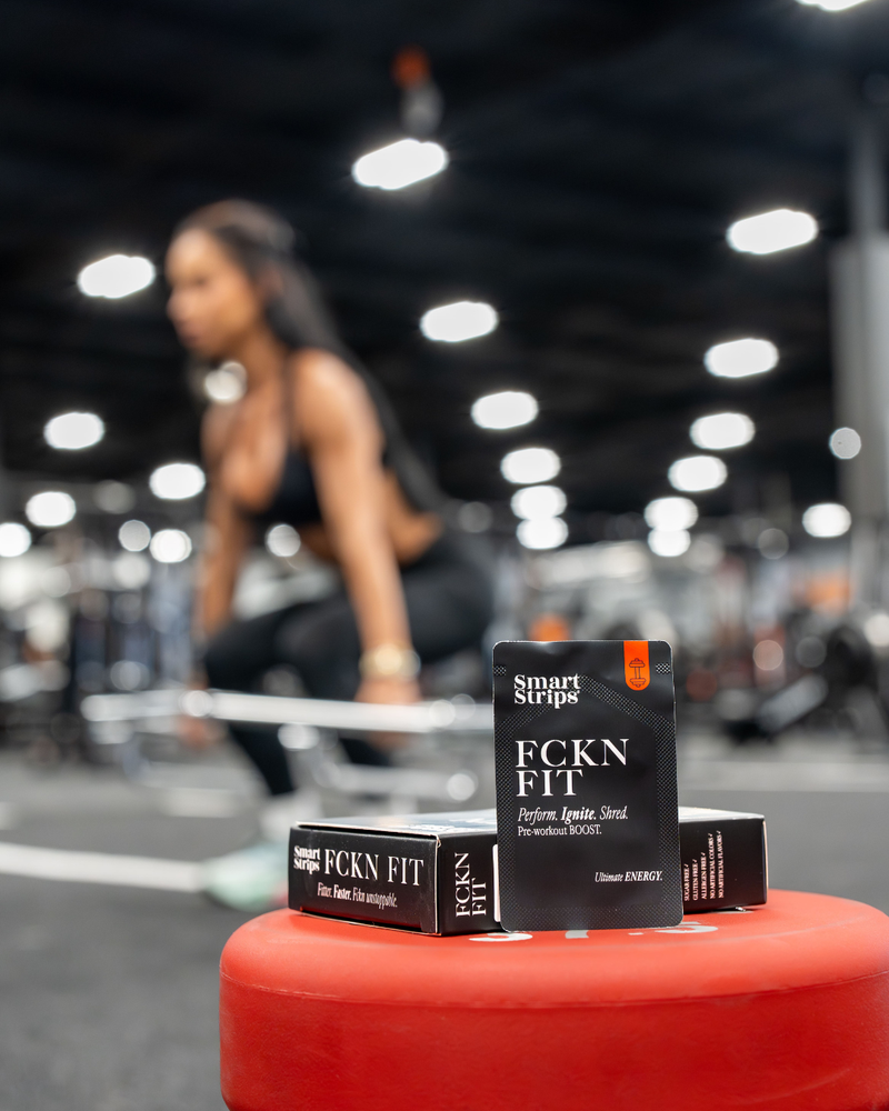 Boxes of Smart Strips FCKN FIT pre-workout oral dissolvable strips in a gym, with a woman training in the background