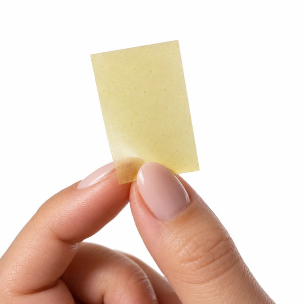 A single Smart Strips AFTR PARTY oral dissolvable strip held between two fingers