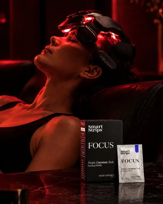 Woman relaxing in a red light therapy headset at Obsidian, with a Smart Strips FOCUS box and sachet in front of her