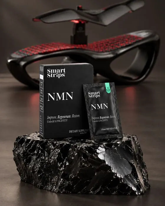 Smart Strips NMN box and sachet on a block of black obsidian stone in front of a wellness bed at Obsidian