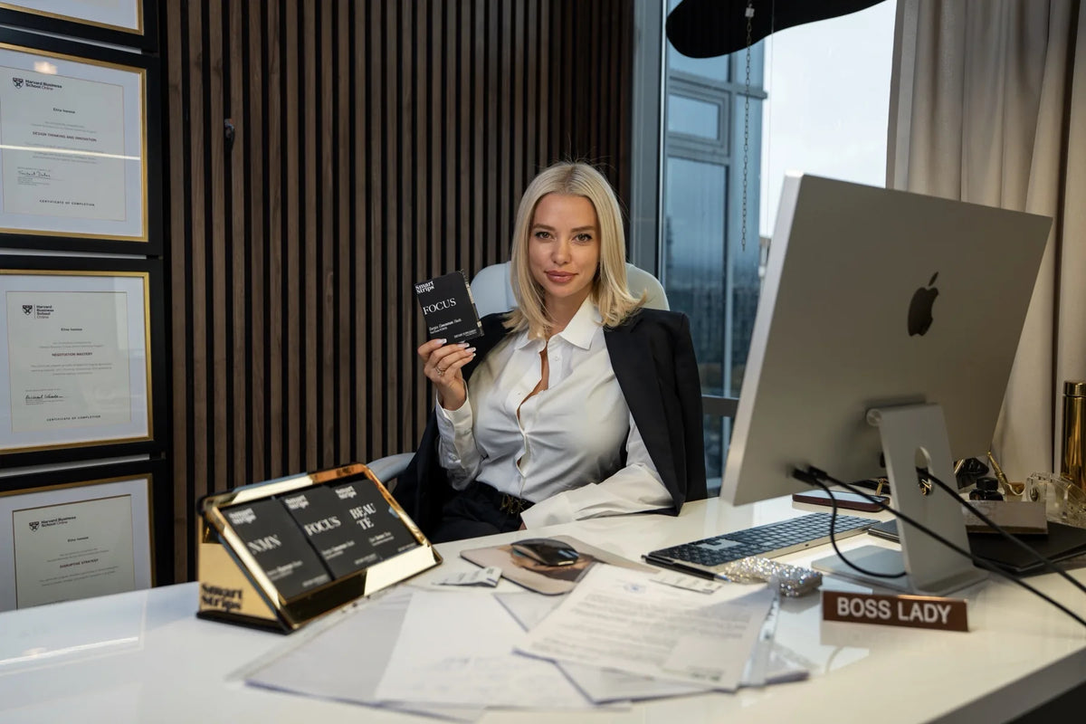 Elina Ivanova-Atanassov, founder of Smart Strips, at her desk with a FOCUS sachet and the Smart Strips display