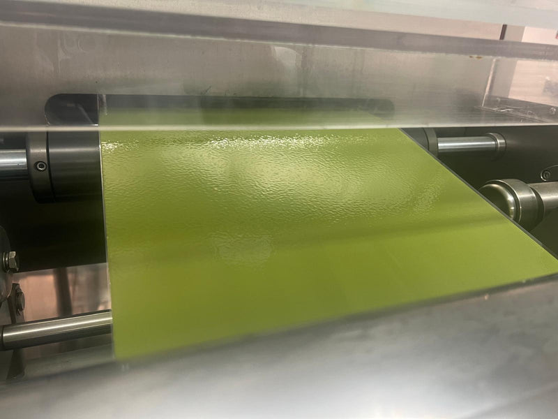 Green sheet of material being processed by a machine